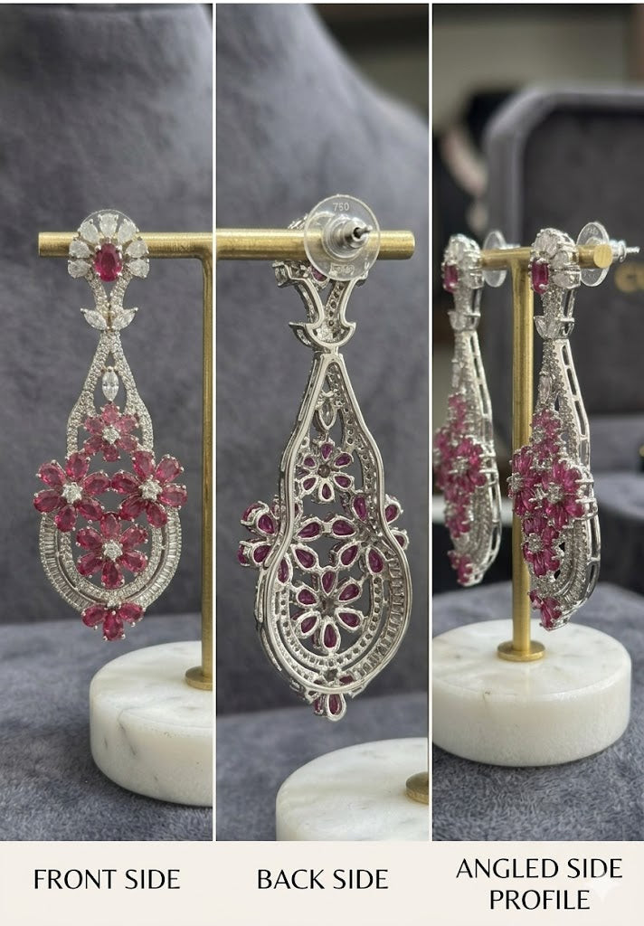 Close-up technical view of the reverse side of a ruby and diamond earring, displaying the detailed white gold filigree work and precision basket settings for the gemstones.