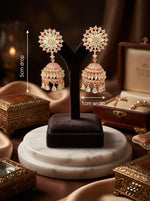  "The Blush Rosette" premium rose gold jhumkas with American Diamond floral studs and tiered bell drops.