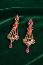 The Luxury gold chandelier drop earrings featuring hot pink ruby gemstones and white cubic zirconia accents, presented in a two-panel product display.