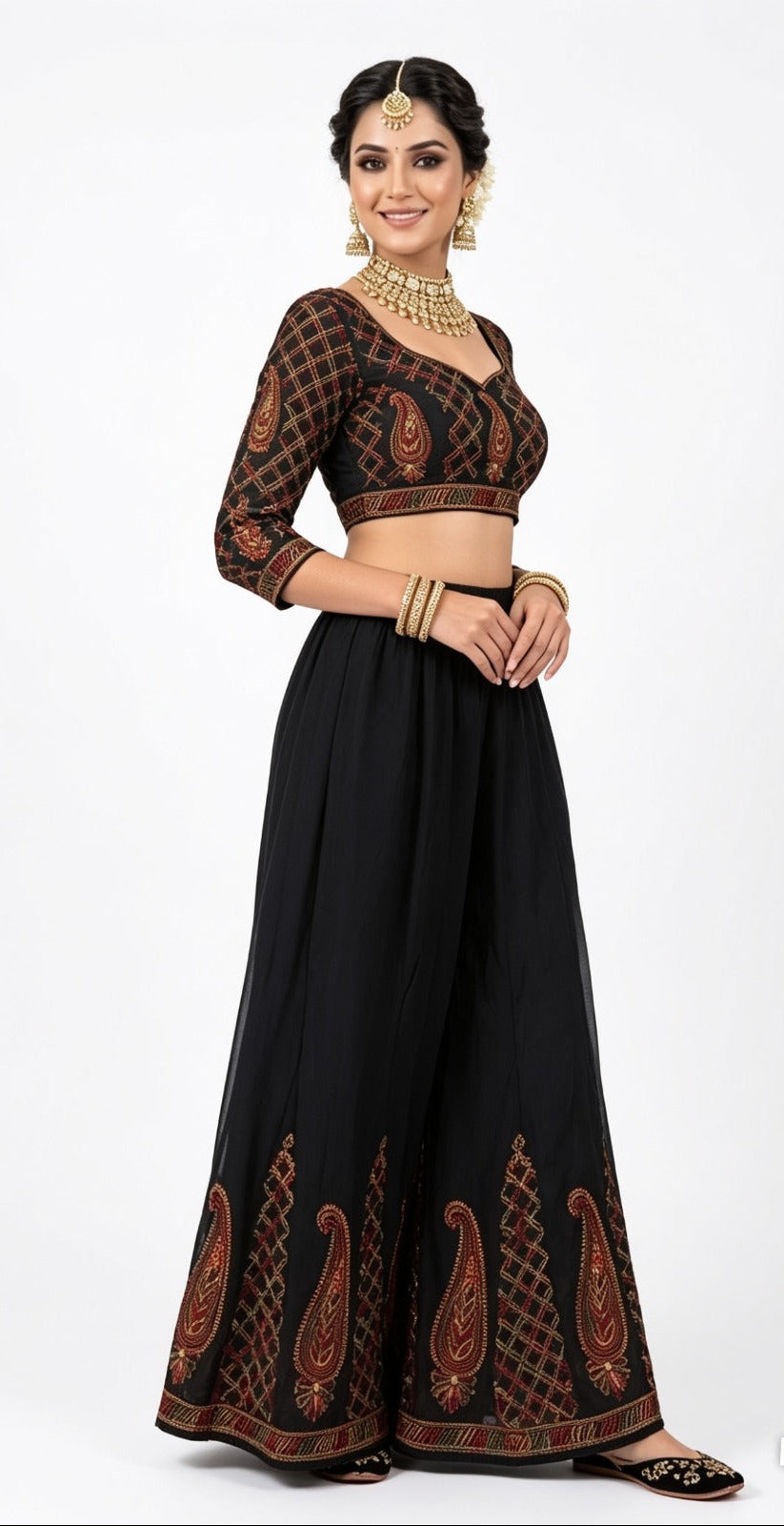 A model standing in a black georgette wide-leg sharara with intricate multi-color paisley embroidery at the hem, worn with a matching top (sharara sold individually.