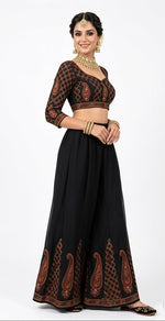 A model standing in a black georgette wide-leg sharara with intricate multi-color paisley embroidery at the hem, worn with a matching top (sharara sold individually.