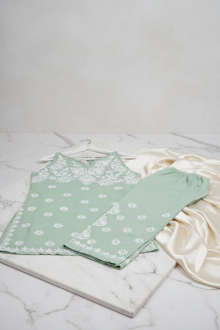 The Mint green colour sleeveless kurti and trousers with white hand embroidery is displayed next to each other on the hangers. 