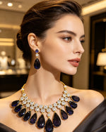 Luxury sapphire blue teardrop statement necklace and earring set, deep blue pear gemstones with brilliant CZ crystals, elegant profile view, premium jewelry perfect for weddings and formal occasions.