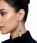 silver american diamond long earrings are being worn by a model with navy blue stone. 