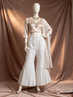 The White cotton sharara with hand bakhiya embroidery and silver kaamdani work. 