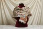 The White pashmina scarf with Kashmiri embroidery in a floral pattern, featuring tassels on the ends.