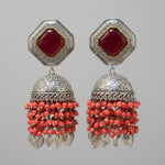 The earrings carries the redstone in the top stud and carrot red hangings underneath the Jhumkey dome and nano oxidised hanging in in the last.