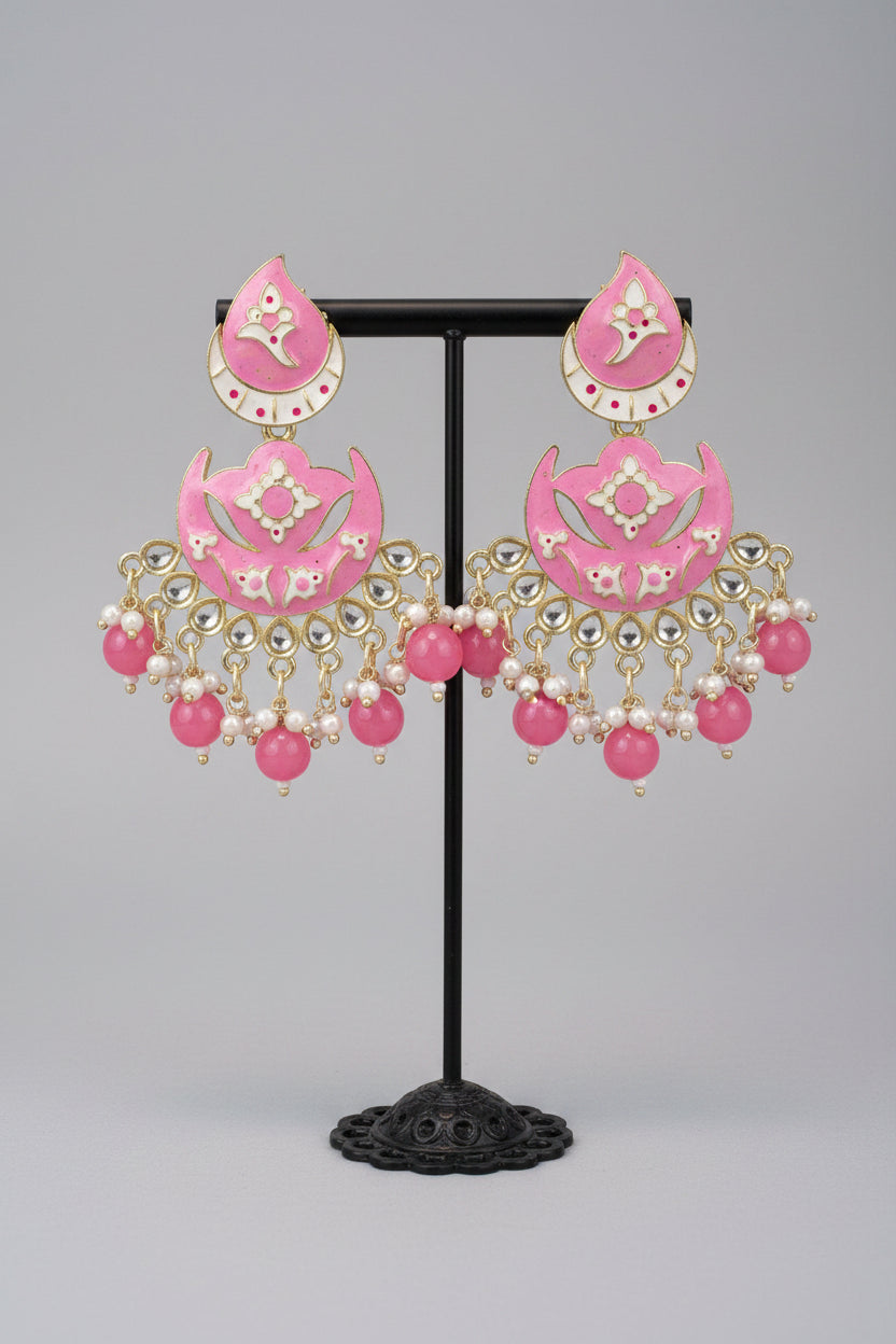 The enamel painted pink colour Pair of earrings displayed on a stand. 
