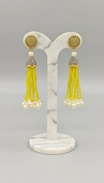 The gold-plated Kundan-studded and pearl-beaded handcrafted earrings, displayed against a black background. 