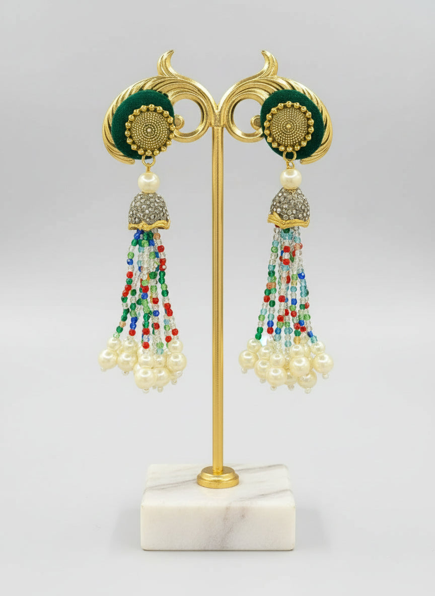 The gold-plated Kundan-studded and pearl-beaded handcrafted earrings, displayed against a black background. Earrings. 