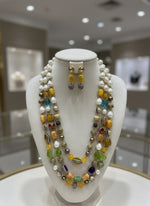 Thegold-plated Kundan-studded and pearl-beaded handcrafted jewellery set, consisting of a necklace and earrings, displayed against a black background. Party wear set. 