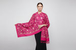 The hot pink colour pashmina scarf with Kashmiri embroidery in a floral pattern, featuring tassels on the ends.
