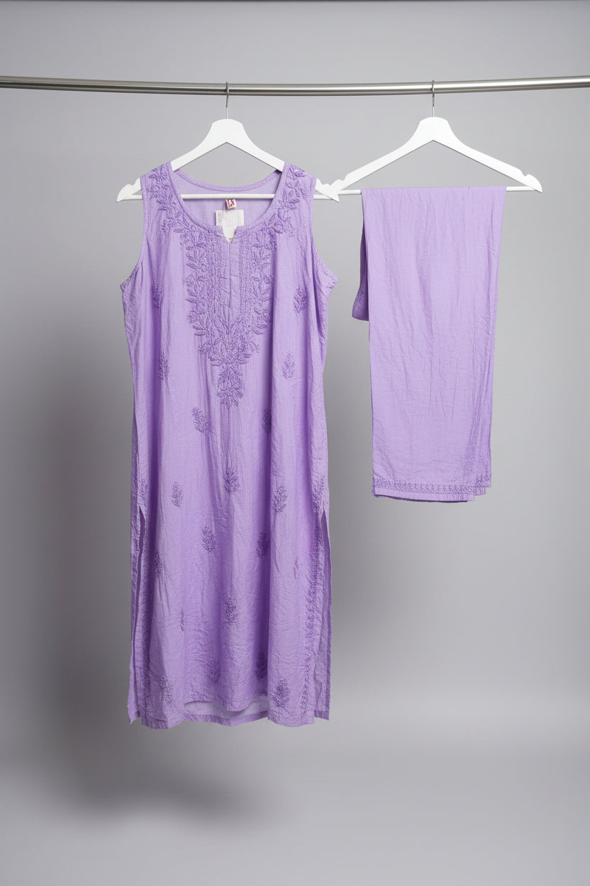 A lavender purple sleeveless tunic top with matching embroidered lace detailing on the neckline and scattered floral motifs, hanging on a white hanger in a retail setting.