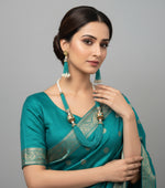 The luxurious Tanjore Art Meenakari turquoise beaded Mala Set featuring a bridal pearl necklace with accompanying earrings, predominantly in gold and white colours with ornate designs. Party wear set. 