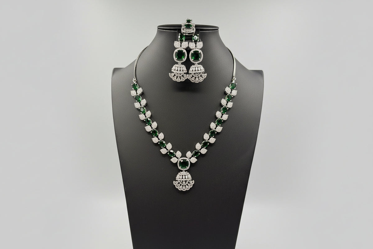 The mannequin showcasing a necklace set with bottle green and white stones, accompanied by earrings and a maang tikka. Party wear set. 