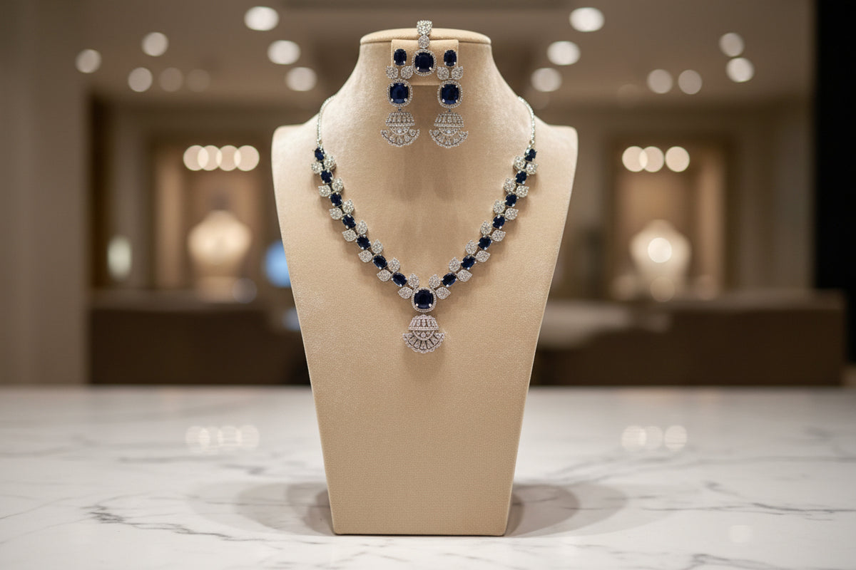 The mannequin showcasing a necklace set with navy blue and white ad stones, accompanied by earrings and a maang tikka.