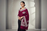 The maroon colour Kashmiri embroidered pashmina shawl with tassels on the ends, displayed on a wooden surface.