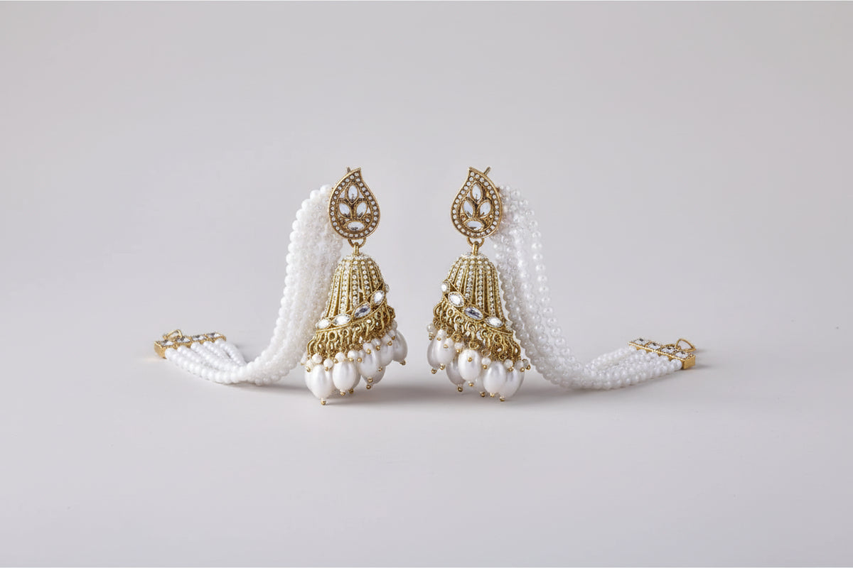 The pair of a woman wearing a white beaded earring with rose gold accents jhumkey.