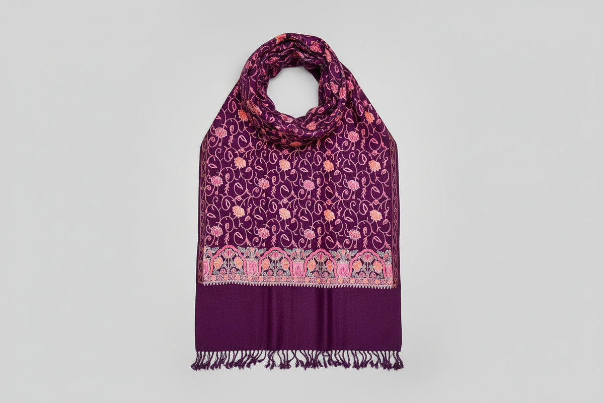 The purple Kashmiri embroidered pashmina scarf with a floral pattern and tassels along the edges.