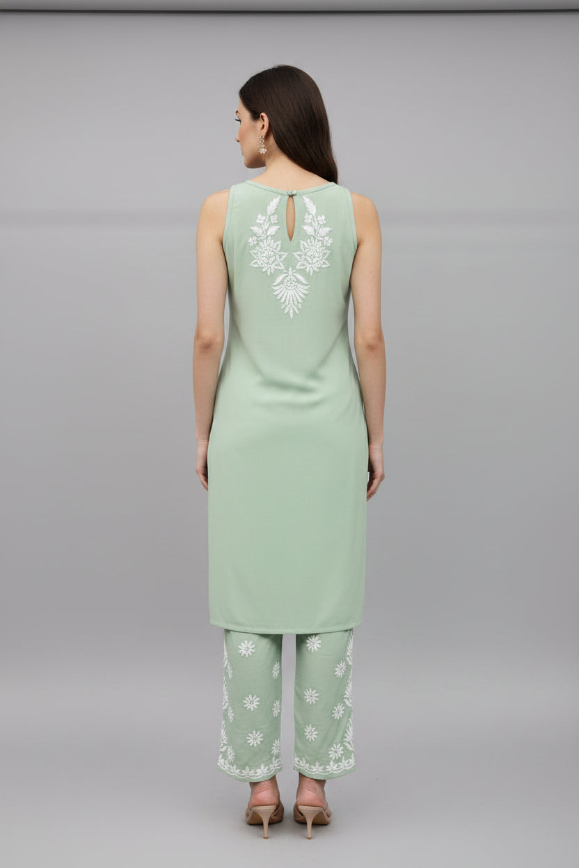 The rear view of Mint green colour sleeveless kurti and trousers with white hand embroidery is displayed next to each other on the hangers. 
