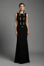 The set of jewellery featuring a long necklace with black-coloured glass beads and metallic accents, paired with matching earrings, displayed on a mannequin bust. Party wear set. 