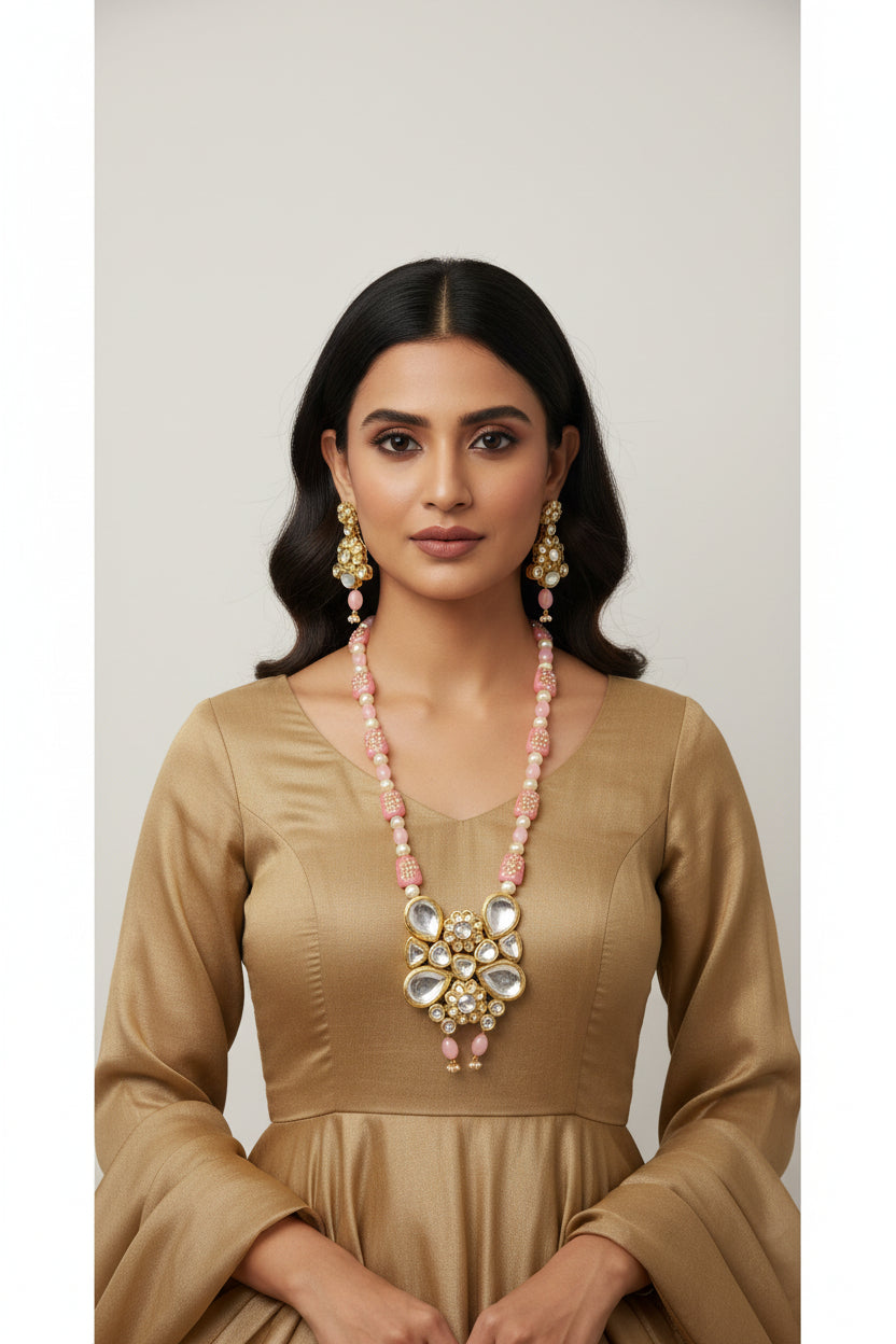 The traditional bridal necklace set displayed on a mannequin, featuring pink and gold colours with intricate detailing and pearl beads. Party wear set. 