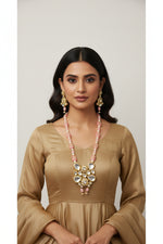 The traditional bridal necklace set displayed on a mannequin, featuring pink and gold colours with intricate detailing and pearl beads. Party wear set. 