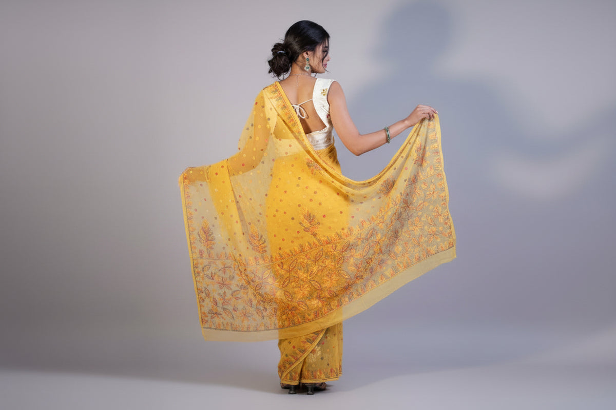 Theyellow colour Georgette Saree with chikankari Keel Jaal Embroidery and Resham Work, with a red blouse piece and traditional Indian jewellery.