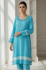 Turquoise traditional Pakistani 3pcs suit with same colour trousers hanging next to the kurti. 