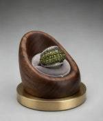The Celestial Radiance American Diamond Cocktail Ring displayed securely in a modern wooden ring holder with a grey velvet cushion and brass base.