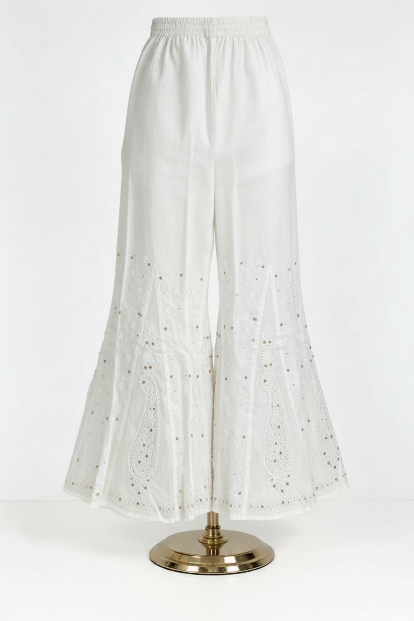 White pure cotton sharara, detailed with fine white thread Bakhiya embroidery and elegant antique gold Kaamdani work, featuring classic paisley motifs, flared silhouette, soft lightweight fabric — perfect for traditional, festive and everyday wear