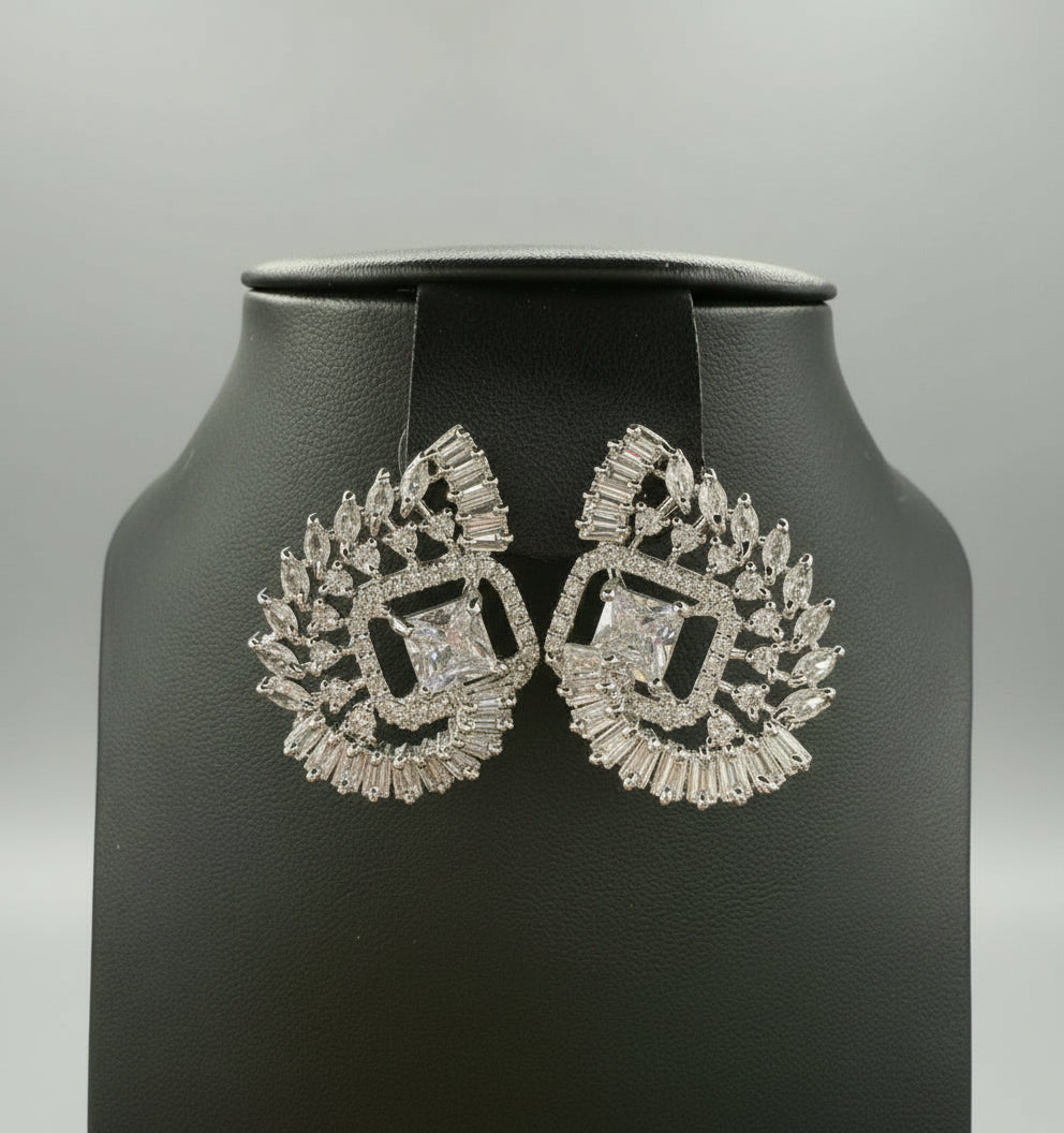 White centre AD stone earrings, featuring a geometric design with intricate detailing, displayed on a black mannequin. Party wear set.