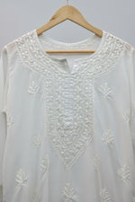 White embroidered kurti is shown and the neckline embroidery is focused for the customer to understand the embroidery on the neckline. 