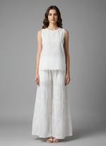 White embroidered pants on a mannequin in a store setting