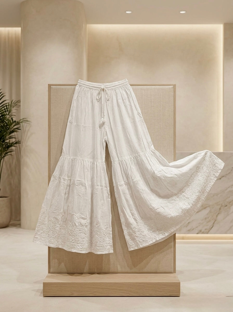 White wide-leg pants on a mannequin against a neutral wall.