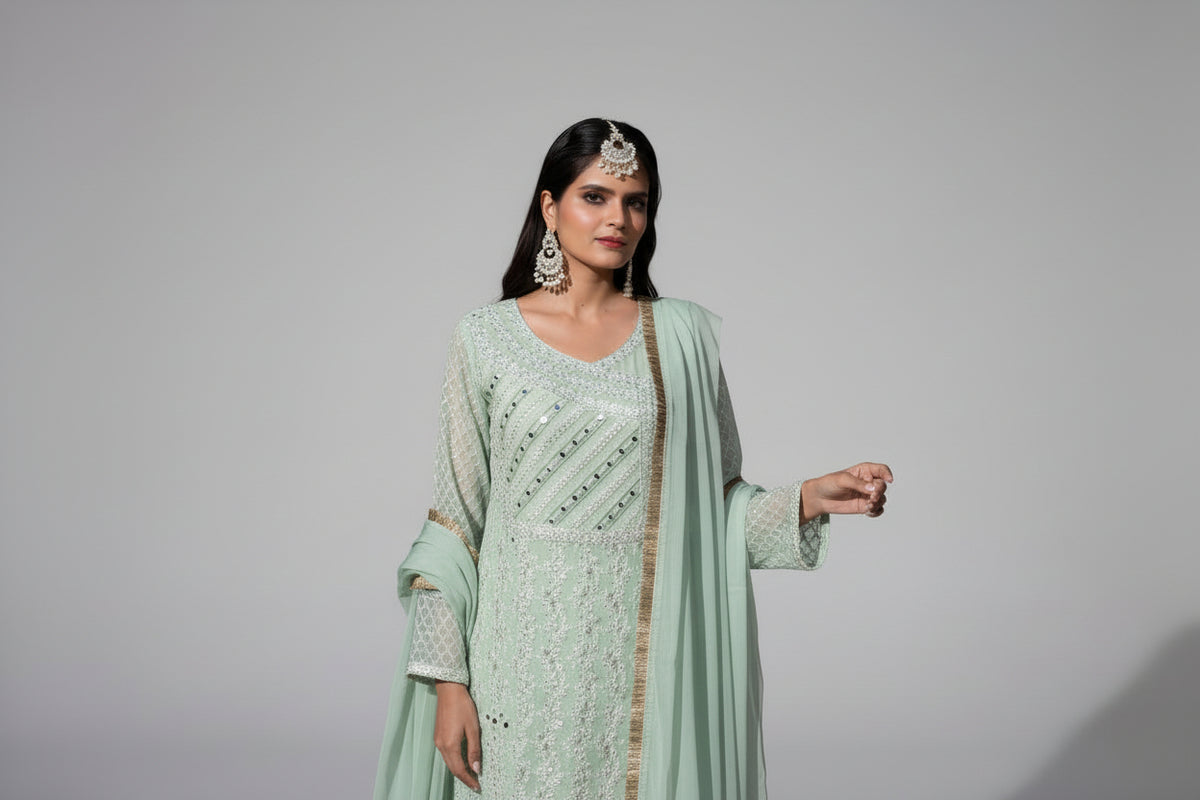 Woman in a light green traditional outfit with a plain background