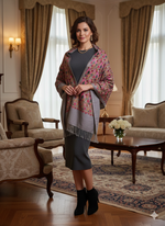 Woman in a patterned shawl standing in an elegant living room.
