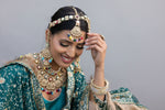 Woman in traditional attire with elaborate jewelry outdoors