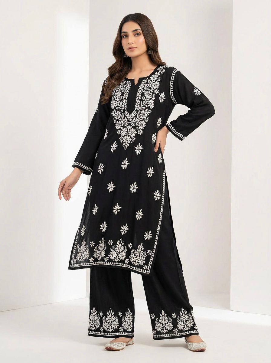 Woman wearing a black base rayon fabric 45 inches long kurti and 38 inches long trousers with white hand embroidered outfit on a white back