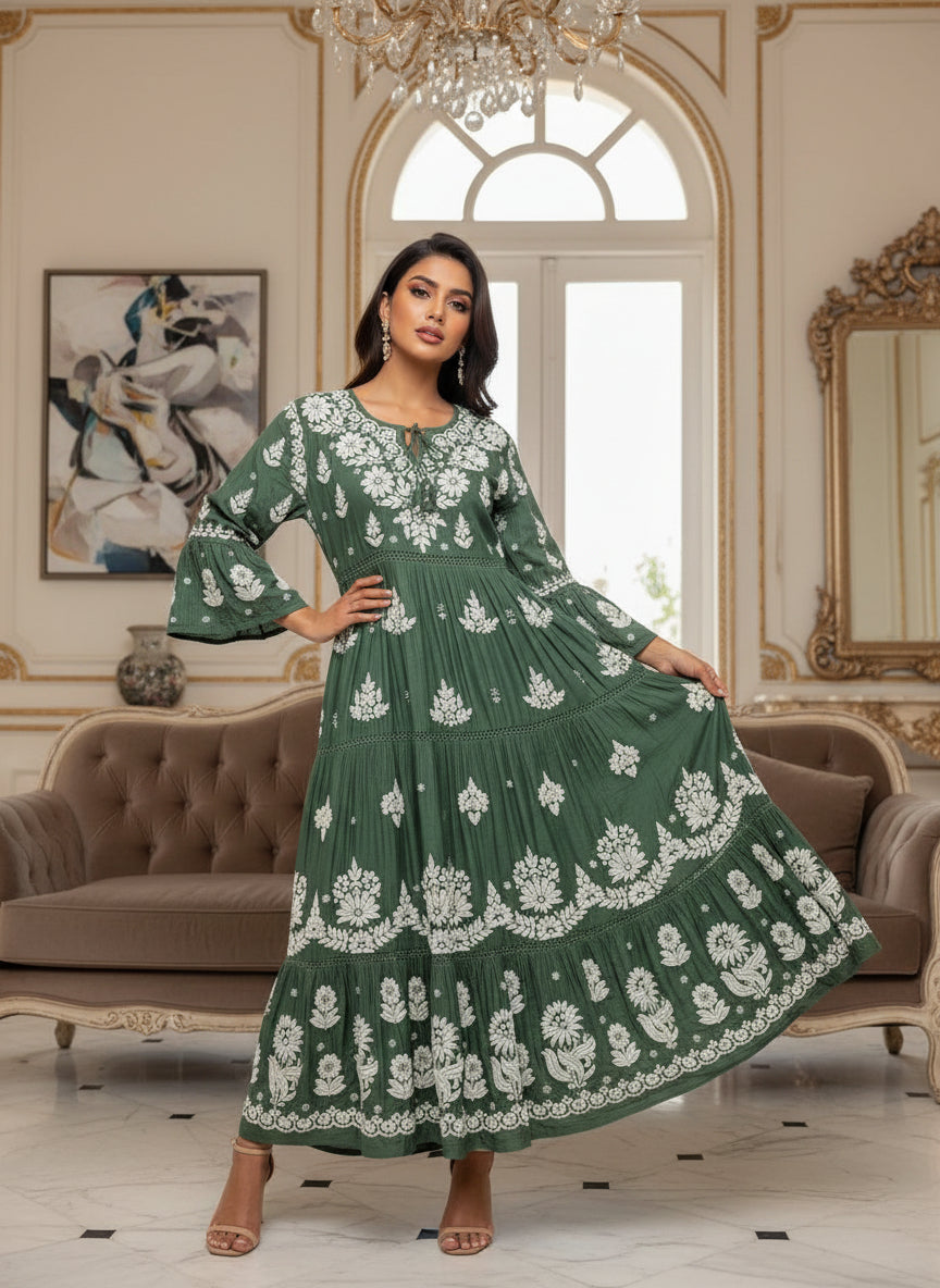 Woman wearing a bottle green colour dress with white floral patterns in a neutral setting.