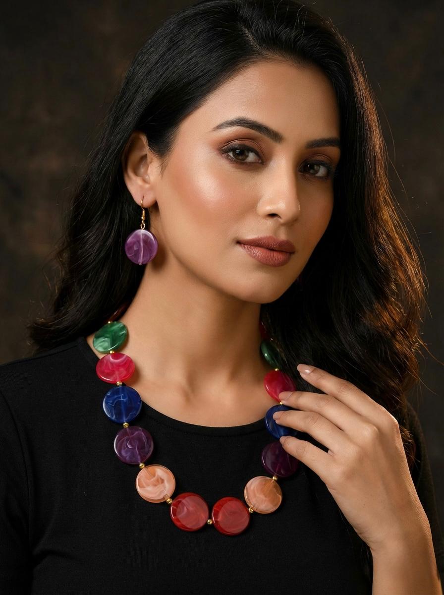 Woman wearing a colorful beaded necklace and earrings against a dark background