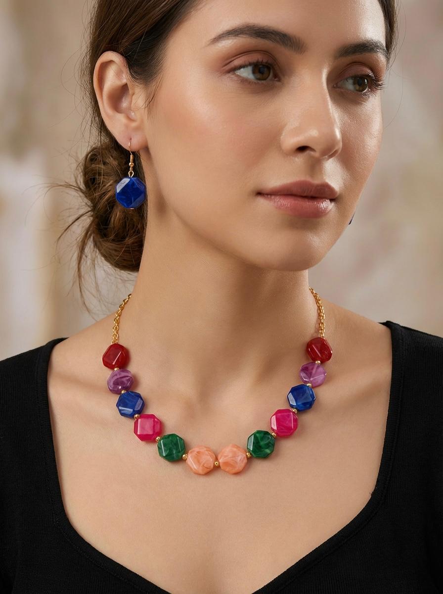 Woman wearing a colorful beaded necklace and earrings against a neutral background