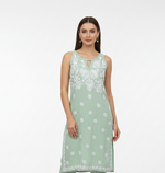 Woman wearing a mint green floral hand embroidered kurti. 
