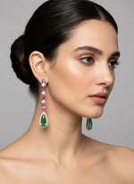 Woman wearing a pair of earrings with gemstones 