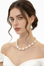 Woman wearing a pearl necklace and earrings on a white background