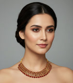 Woman wearing a red and gold necklace against a gray background