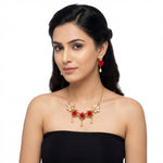 Woman wearing a red and gold necklace and matching earrings.