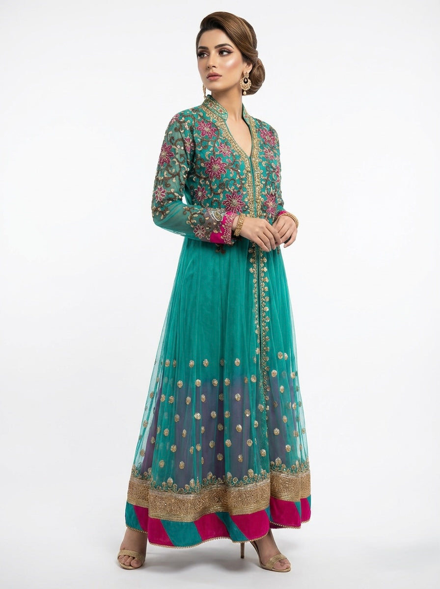 Woman wearing a teal and pink traditional outfit with floral patterns on a white background