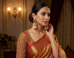 Woman wearing a traditional saree with gold jewellery indoors