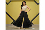Woman wearing a whitetop and black flared hand embroidered gharara trousers 